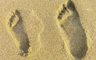 fußabdruck fußspuren auf dem strandsand am wasser mexiko. foto