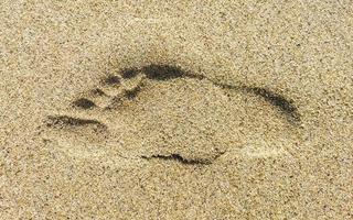 fußabdruck fußspuren auf dem strandsand am wasser mexiko. foto