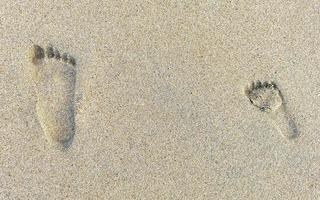 fußabdruck fußspuren auf dem strandsand am wasser mexiko. foto