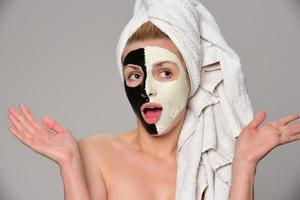 schönes weibliches modell mit schwarz-weißer gesichtskosmetikmaske foto