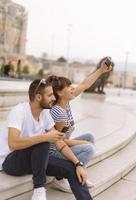 ein paar touristen, die spaß haben, im urlaub auf der straße der stadt spazieren zu gehen - glückliche freunde, die im urlaub zusammen lachen - menschen- und urlaubskonzept foto