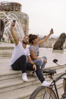 ein paar touristen, die spaß haben, im urlaub auf der straße der stadt spazieren zu gehen - glückliche freunde, die im urlaub zusammen lachen - menschen- und urlaubskonzept foto