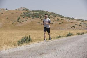 sportlicher Läufer, der im Sommer auf dem Bergplateau läuft foto