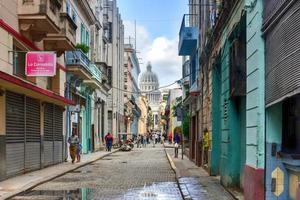 Havanna, Kuba - 8. Januar 2017 - Menschen, die durch die Straßen der Altstadt von Havanna gehen, mit dem Gebäude der nationalen Hauptstadt im Hintergrund. foto