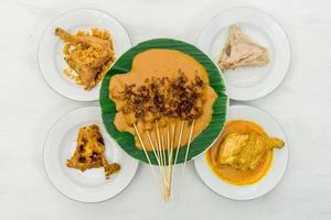 Blick von oben auf Satay Padang, Brathähnchen und Hühnchen-Curry auf Teller. indonesisches essen foto