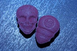 rosa schädel ecstasy pille nahaufnahme hintergrund hochwertiger druck lila armee dope betäubungsmittel substanz hochdosis psychedelische lebensart foto