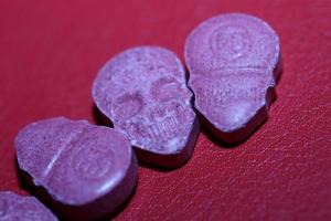 rosa schädel ecstasy pille nahaufnahme hintergrund hochwertiger druck lila armee dope betäubungsmittel substanz hochdosis psychedelische lebensart foto