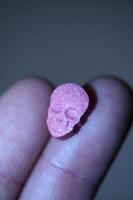 rosa schädel ecstasy pille nahaufnahme hintergrund hochwertiger druck lila armee dope betäubungsmittel substanz hochdosis psychedelische lebensart foto