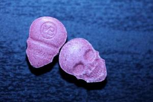 rosa schädel ecstasy pille nahaufnahme hintergrund hochwertiger druck lila armee dope betäubungsmittel substanz hochdosis psychedelische lebensart foto