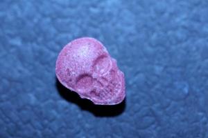 rosa schädel ecstasy pille nahaufnahme hintergrund hochwertiger druck lila armee dope betäubungsmittel substanz hochdosis psychedelische lebensart foto