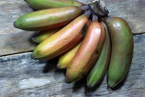 große Bananenfrüchte auf Holzhintergrund foto