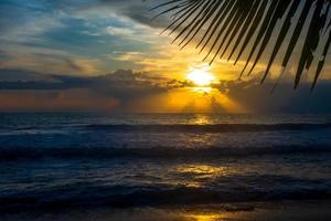 dramatischer sonnenuntergang über asiatischem tropischem strand foto