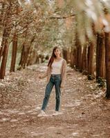 Porträt eines Mädchens mit braunen Haaren, in einer Strickjacke, bei einem Spaziergang im Wald. foto