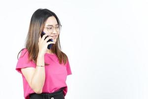 Sprechen auf dem Smartphone mit glücklichem Gesicht der schönen asiatischen Frau isoliert auf weißem Hintergrund foto