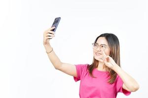 Machen Sie ein Selfie mit dem Smartphone einer schönen Asiatin, die auf weißem Hintergrund isoliert ist foto