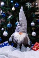 Weihnachtselfen Dekorationen. vier zwerge mit weihnachtsgeschenk sitzen auf einem holzregal. Weihnachts- und Neujahrskonzept, foto