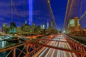 new york city manhattan downtown skyline bei nacht von der brooklyn bridge mit dem tribute in light zur erinnerung an den 11. september. foto