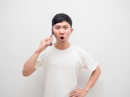 asiatischer mann spricht mit smartphone in der hand ernstes gesicht sagt nein blick in die kamera auf weißem hintergrund foto