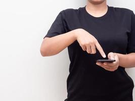Closeup Körper Frau schwarzes Hemd Touchscreen auf ihrem Handy mit Kopie Raum weißen Hintergrund foto