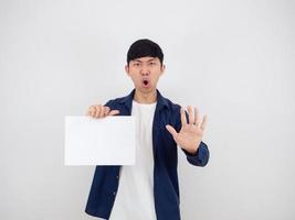 asiatischer Mann, der ein leeres Blatt hält und die Hand zeigt, sagt kein ernstes Gesicht auf weißem, isoliertem Hintergrund, foto