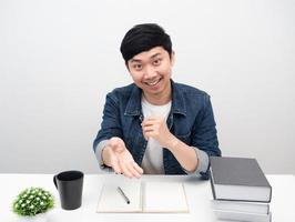 Fröhlicher Mann lächelnd sitzen am Arbeitsplatz Schreibtisch Geste empfehlen foto
