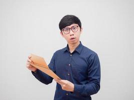 asiatischer Mann mit Brille, der einen Dokumentumschlag hält und sich verwirrt auf den weißen Hintergrund des Kameraporträts fühlt foto