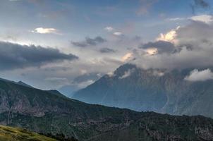 hügelige landschaft in der nähe des dorfes gergeti in georgia, unter dem berg kazbegi. foto