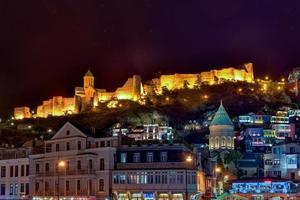 Blick auf die Altstadt von Tiflis, Georgien und die Festung Narikala nach Sonnenuntergang. foto