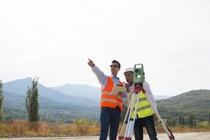 Vermessungsingenieur misst das Niveau auf der Baustelle. Vermessungsingenieure sorgen für genaue Messungen, bevor sie große Bauprojekte in Angriff nehmen. foto