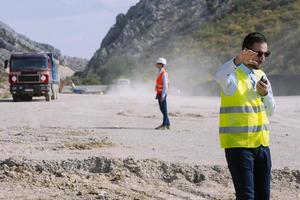 Vermessungsingenieur misst das Niveau auf der Baustelle. Vermessungsingenieure sorgen für genaue Messungen, bevor sie große Bauprojekte in Angriff nehmen. foto