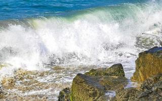 große surferwellen und felsen am strand puerto escondido mexiko. foto