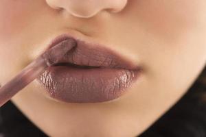 make-up, lippen-make-up. frau führt make-up durch, malt lippenstift foto