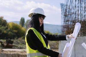 Vermessungsingenieur misst das Niveau auf der Baustelle. Vermessungsingenieure sorgen für genaue Messungen, bevor sie große Bauprojekte in Angriff nehmen. foto