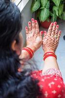 schöne frau, die sich als indische tradition mit henna-mehndi-design an beiden händen verkleidet hat, um das große fest von karwa chauth zu feiern, karwa chauth-feiern der indischen frau für ihren ehemann foto