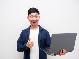 asiatischer mann, der laptopdaumen hoch hält, glückliches lächelngesicht auf weißem hintergrund foto