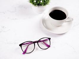 Gläser Kaffeetasse mit Blumenvase auf dem Marmortisch Hintergrund kopieren Raum Morgen foto