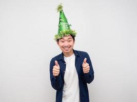 fröhlicher Mann mit grünem Hut, Daumen nach oben, weißer Hintergrund foto