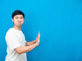 asiatischer mann geste push handgefühl schwerer kopierraum blauer hintergrund foto
