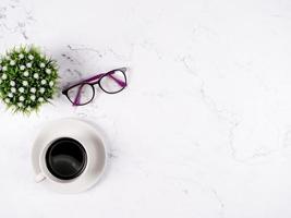 Kaffeetassegläser und Blumenvase auf Draufsicht-Kopienraum des weißen Marmorhintergrundes foto