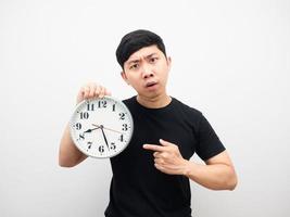 asiatischer mann zeigt mit dem finger auf die uhr und fühlt sich wütend, spätes konzept foto