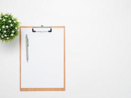 Stift auf Dokumententafel mit Vase auf Draufsicht des Tischkopienraums foto