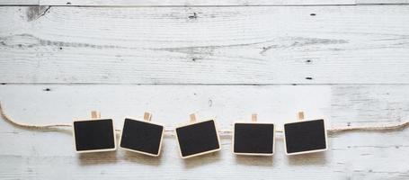 Fünf kleine Clip-Tafel mit Seil-Array-Linie auf weißem Holztisch Naturschatten unter Raum, Ideenschild-Konzept foto