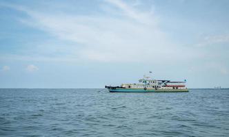 tourismusschiff auf der landschaft des ozeans und des blauen himmels, reisebootskonzept für transportreisende in thailand mit schönem meer und himmel foto