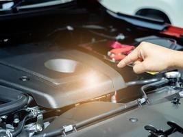 Hand zeigt mit dem Finger auf den neuen Motorinnenraum das neue Auto mit leichter Fackel foto