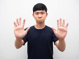 schweigen mann mit band schließen mund zeigen hand stopp isoliert foto