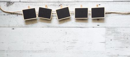 Fünf kleine Clip-Tafel mit Seil-Array-Linie auf weißem Holztisch Naturschatten unter Raum, Ideenschild-Konzept foto