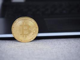 Closeup Gold Bitcoin mit Tastatur-Laptop foto