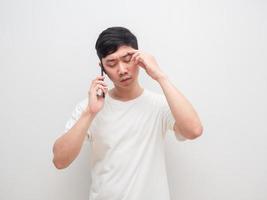 Mann, der mit Handy spricht und sich angespannt fühlt, berührt seinen Kopf auf weißem Hintergrund foto