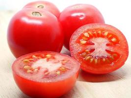Frische rote Tomatenscheibe auf weißem Naturschatten foto