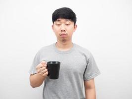 asiatischer mann, der kaffeetasse hält, schläfriges gefühlsporträt foto